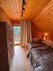 a bedroom with two beds in a wooden cabin at Przystanek Beskidy in Brenna