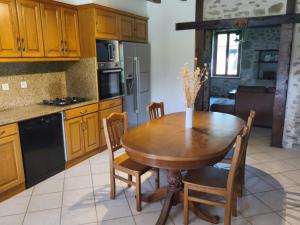 a kitchen with a wooden table and some chairs at Gite 15 pers tout compris Les Lucioles in Crevant +10 photos