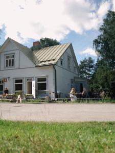 a group of people sitting outside of a house at Majatalo Kukkasrinne in Lahti