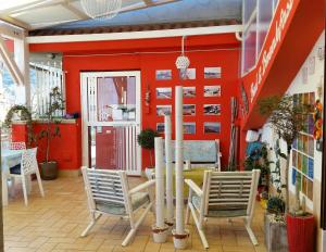 ein Esszimmer mit roten Wänden und Stühlen in der Unterkunft Ciccolella B&B in Vibo Valentia Marina