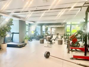a gym with treadmills and exercise equipment and plants at U Mall Condo in Sihanoukville