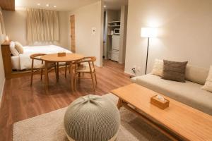 a living room with a couch and a table at SOULEIADO Shinosaka in Osaka