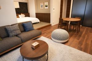 a living room with a couch and a bed and a table at SOULEIADO Shinosaka in Osaka