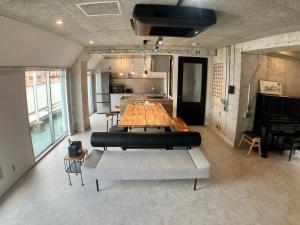 a large room with a table and a piano at Guesthouse Matsu 別館 in Osaka