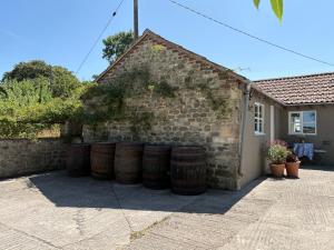 a group of barrels leaning against a brick wall at The Old Dairy in Warminster