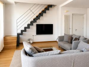 ein Wohnzimmer mit zwei Sofas und einem Fernseher in der Unterkunft Montevecchio 56 in Fano