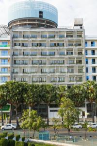 a large building with palm trees in front of it at Stadion Residences in Phumĭ Prêk Chrey