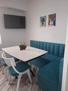 a dining room with a table and a blue couch at Studio Niki in Smolyan