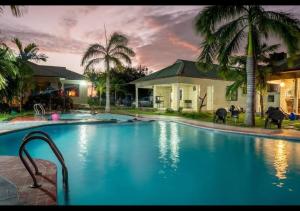 a large swimming pool in front of a house at Paradiso Hotel in Dar es Salaam +6 photos