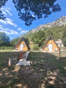 a couple of barns with a mountain in the background at Gnijezdo ispod greda in Šavnik
