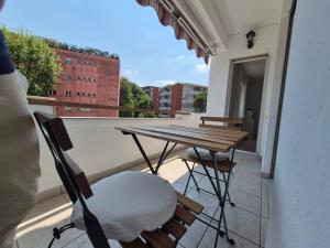a balcony with a table and chairs on a balcony at Sunlit Lugano & Parking Free in Massagno