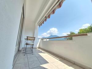 a chair sitting on the balcony of a house at Sunlit Lugano & Parking Free in Massagno