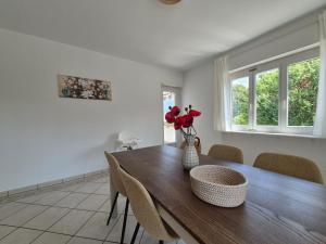 a dining room table with a vase of flowers on it at Sunlit Lugano & Parking Free in Massagno