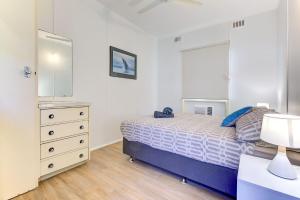 a bedroom with a bed and a dresser and a mirror at Ruby in Exmouth