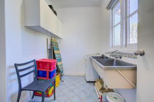 a kitchen with a sink and a chair at Ruby in Exmouth
