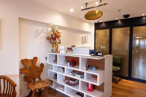 a room with a white shelf with flowers on it at iNN at Temple St by Q Loft Newly Renovated in Singapore