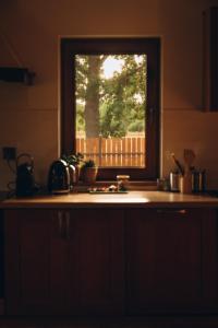 a kitchen with a window above a kitchen counter at Między łąką a lasem in Żdżar