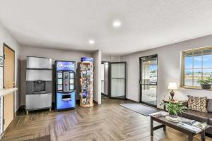 a living room with a soda machine and a table at Super 8 by Wyndham East Stroudsburg - Poconos in East Stroudsburg
