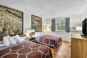 a hotel room with two beds and a flat screen tv at Super 8 by Wyndham East Stroudsburg - Poconos in East Stroudsburg +51 photos