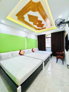 a bedroom with two beds and a green wall at Khách sạn Tuyết Minh in Xã Thang Tam