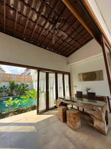 a room with a wooden bench and a large window at Balcony Living Apartment in Seminyak