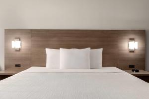 a bed with white pillows in a hotel room at Baymont by Wyndham La Grange KY Southeast in La Grange +25 photos