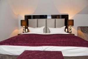 
a bed with a white comforter and pillows at Arena Villa am Wasserpark in Frankfurt/Main
