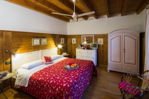 - une chambre avec un grand lit et une couverture rouge dans l'établissement B&B La Casa Di Campagna, à Bergame