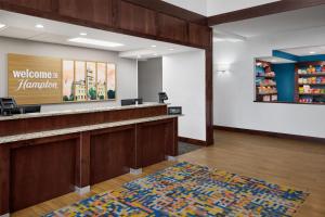 a waiting room with a welcome to hampton inn pharmacy at Hampton Inn Lawrence in Lawrence +25 photos