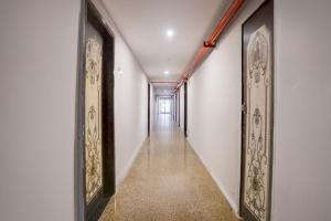 a long hallway with white walls and gold framed pictures at Hotel O Bhavnagar Bus Terminal Formerly Jubliee in Bhavnagar +29 photos
