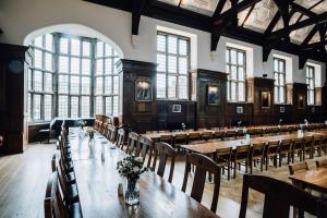 a large room with tables and chairs and windows at Selwyn College, Cambridge in Cambridge