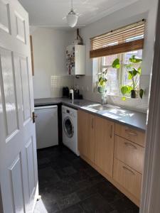 a kitchen with a sink and a washing machine at Sansome House in Worcester