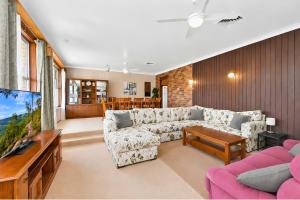 a living room with a couch and a tv at Coal d' Vine VIEW - Cessnock NSW in Cessnock