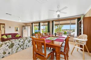 a dining room with a table and chairs and a couch at Coal d' Vine VIEW - Cessnock NSW in Cessnock