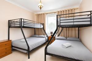 a bedroom with two bunk beds and a window at Coal d' Vine VIEW - Cessnock NSW in Cessnock +6 photos