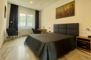 a bedroom with a bed and a desk with chairs at DREAM VIEW Saguramo in Saguramo +51 photos
