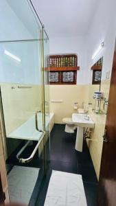 a bathroom with a glass shower and a sink at Royal Eco Lodge in Kandy