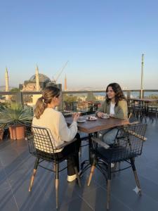 two women sitting at a table on a roof at Nomade Old City Hotel in Istanbul