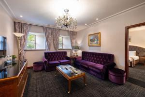 a living room with purple furniture and a bed at Taoyuan Yuehua Hotel & Golf Club in Longtan