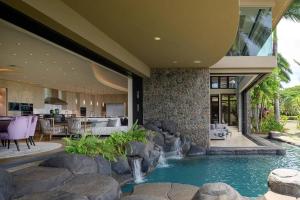 a house with a swimming pool in front of it at Magnificent Oceanfront West Maui in Lahaina