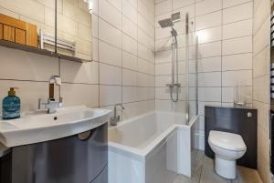 a bathroom with a sink and a toilet and a bath tub at Ocean view in Swanage +26 photos