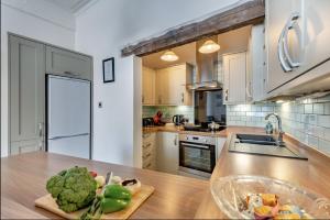 a kitchen with a wooden counter top with a bowl of vegetables at Ocean view in Swanage