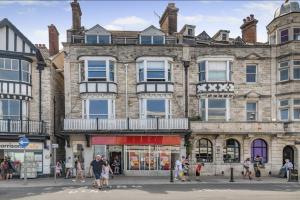 a large stone building with people walking in front of it at Ocean view in Swanage