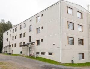 a large white building with a bike parked in front of it at Apartment Naavis in Rovaniemi