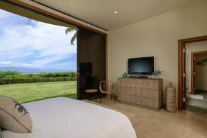 a bedroom with a bed and a tv and a window at Magnificent Oceanfront West Maui in Lahaina