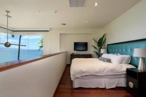 a bedroom with a large bed and a television at Magnificent Oceanfront West Maui in Lahaina +41 photos
