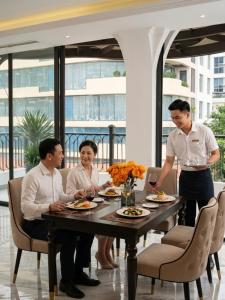 a group of three people sitting around a table at 22 Land Hotel in Hanoi