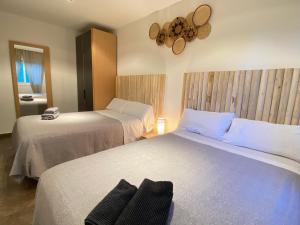 a bedroom with two beds and a mirror at Can Vinyals Holiday Home in Castellar