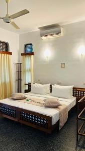 a bedroom with a large bed with white sheets at Royal Eco Lodge in Kandy