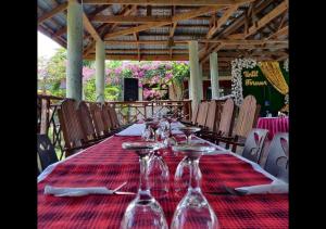 a long table with wine glasses on a red table cloth at Paradiso Hotel in Dar es Salaam